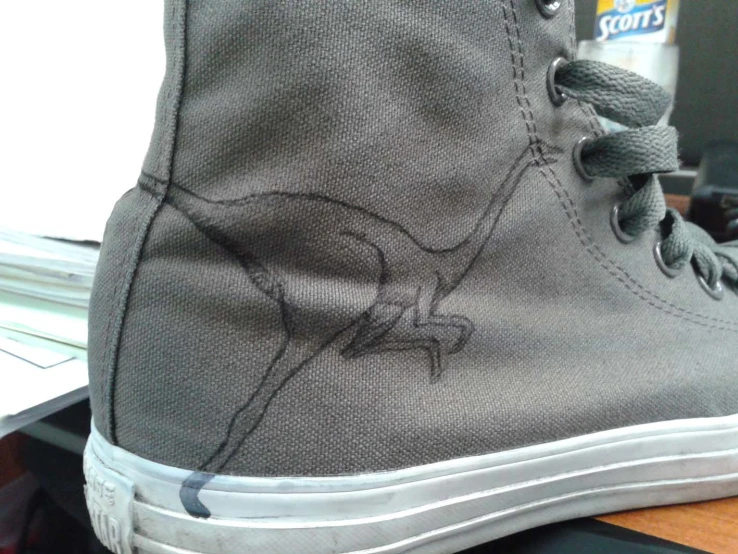 a pair of grey shoes with a kangaroo on it