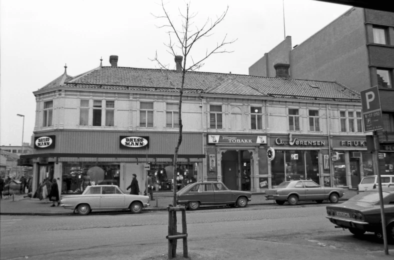 a couple cars parked in front of some shops