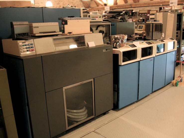 several machines lined up in a warehouse, one being used as a dryer