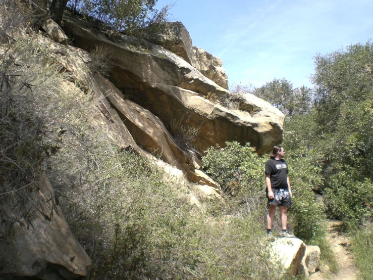 a man is standing on top of a cliff looking out