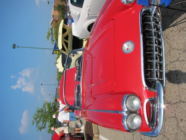 some classic cars parked and others looking at them