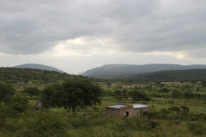 a small shack sits alone in the green hills