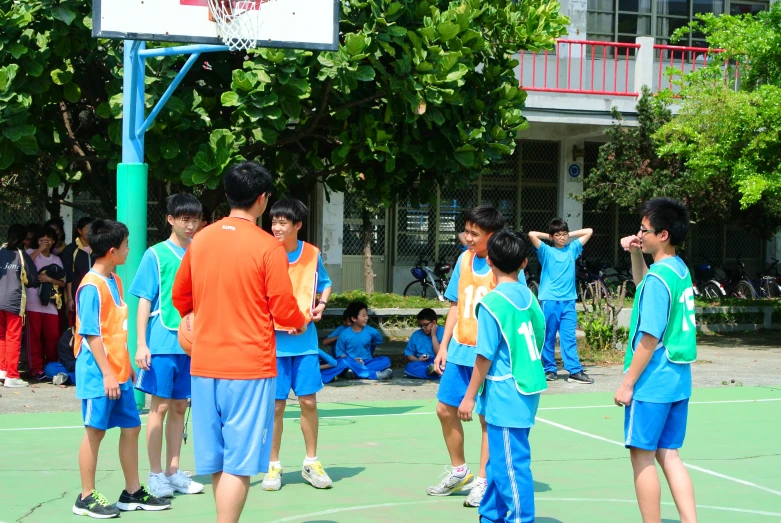 a group of children on the court with their hands up