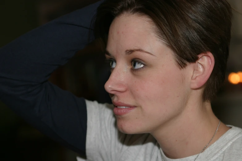 a young lady wearing a necklace with a diamond in the center