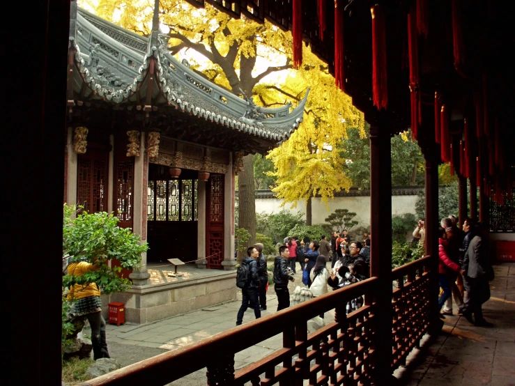 a chinese building with red columns and yellow leaves