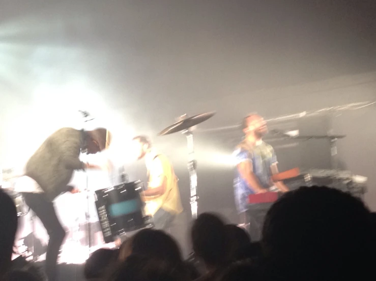 some musicians playing on the stage and a crowd watching