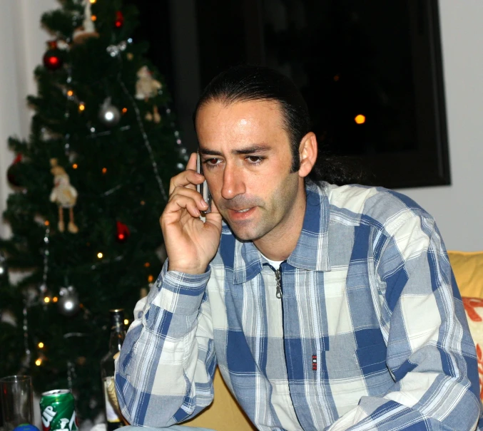 a man with an earpiece and shirt on while talking on the phone