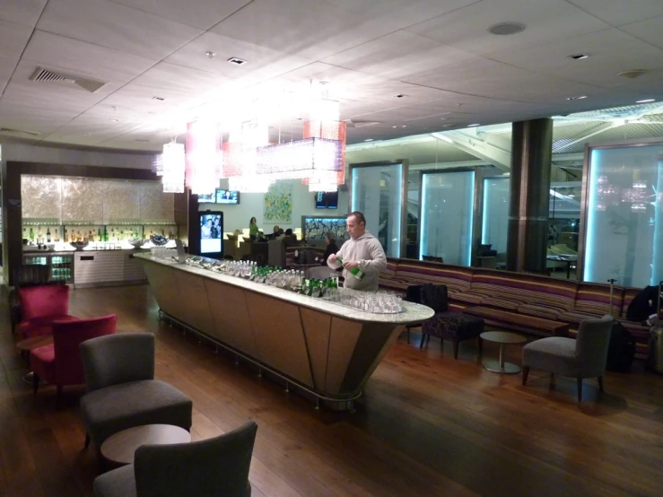 a man standing in front of a bar filled with bottles