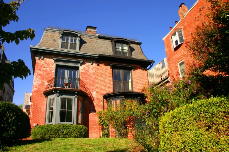 a large brick home surrounded by lush vegetation