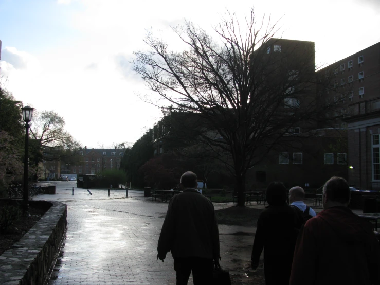 several people walking down a road carrying bags