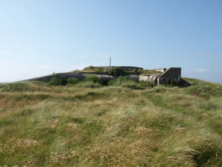 a couple of benches sitting on top of a grass covered hill