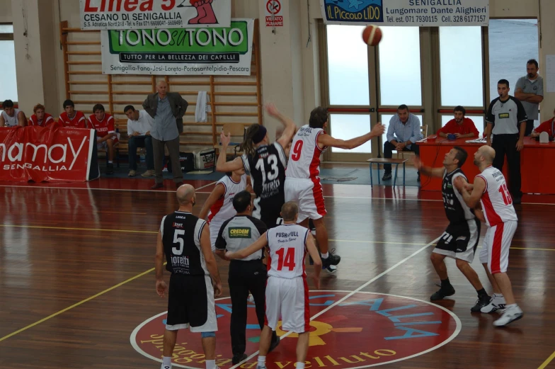 several people playing basketball while others watch