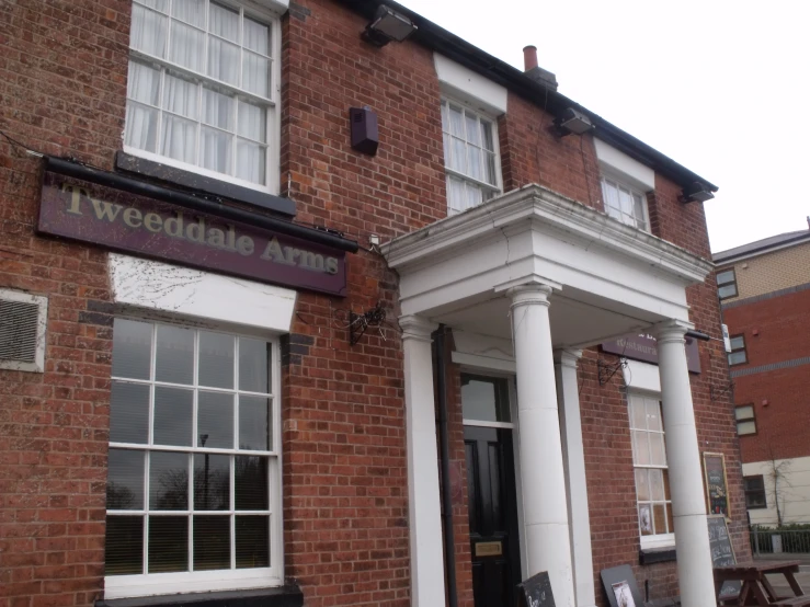 a brown brick building with white pillars and white windows