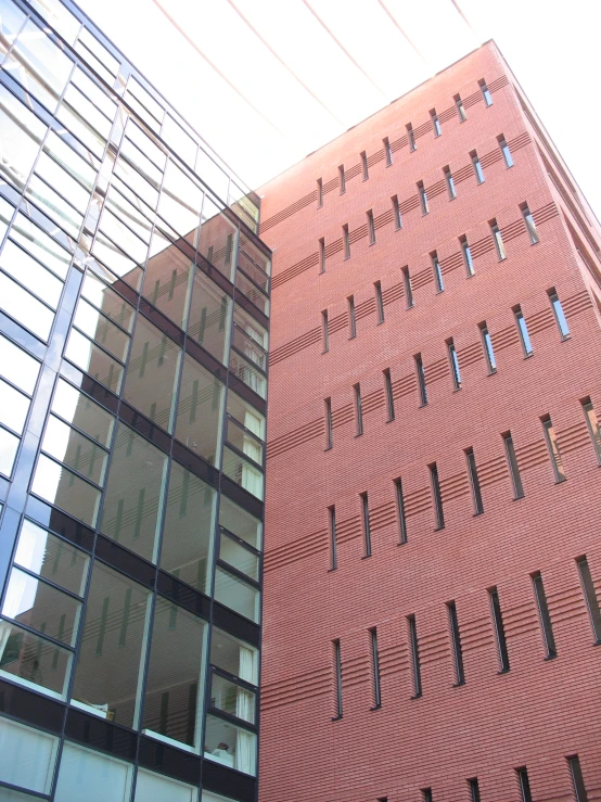 the side of two tall brick buildings reflected in the windows