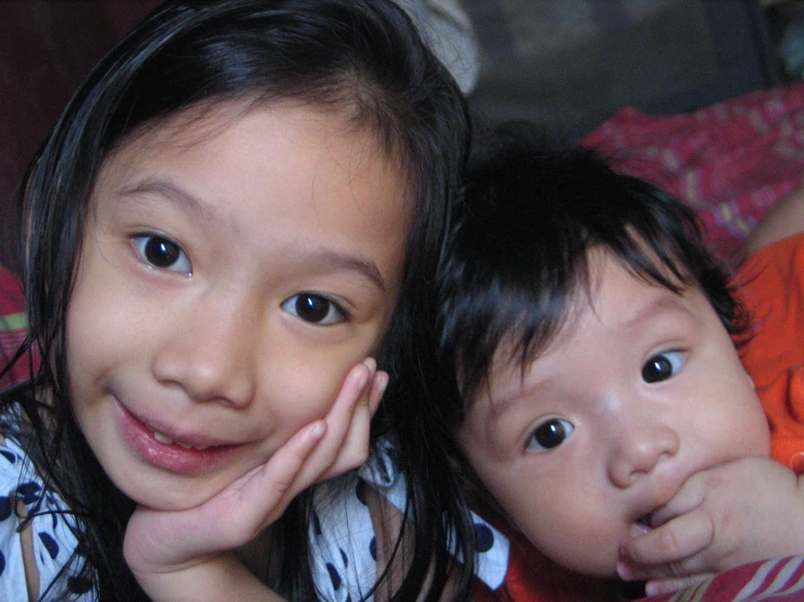 two children laying next to each other and smiling
