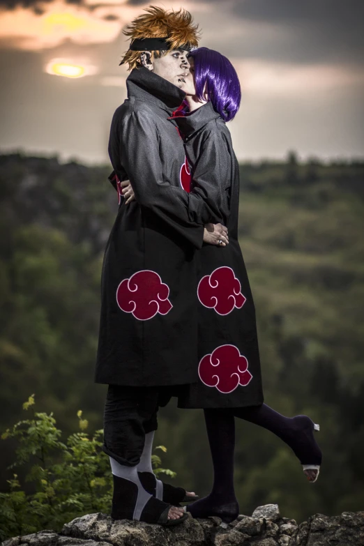 two people standing on a ledge looking off into the distance