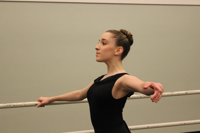 the woman in the ballet outfit is holding on to the rail