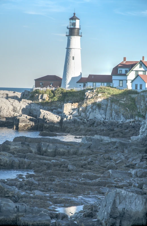 a very large white light house sitting on the top of a hill