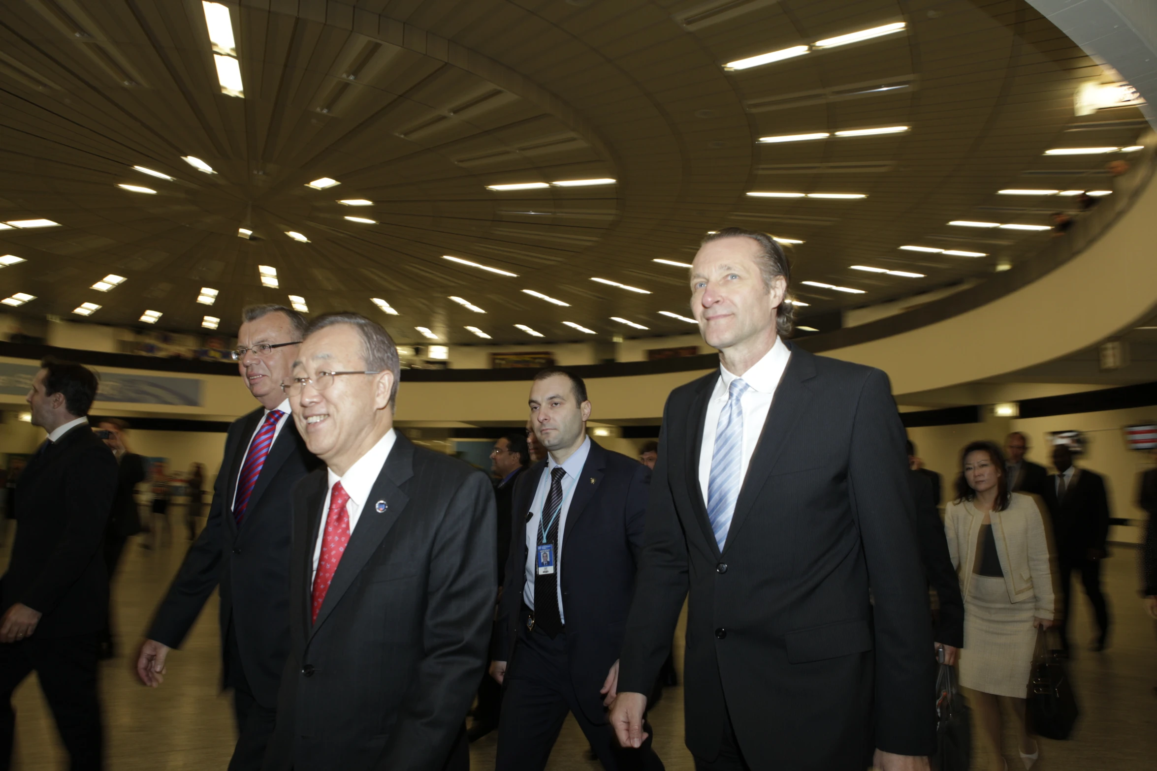 a group of men walking down a hall while holding hands