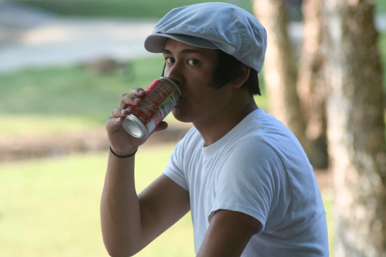 man drinking can of coca cola on a sunny day