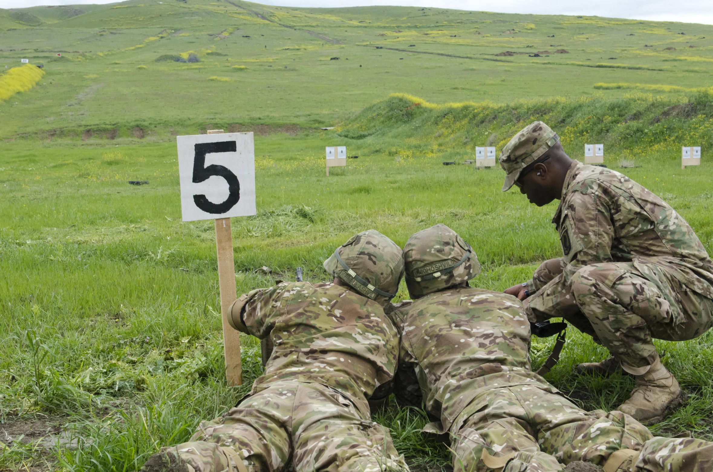 an army soldier showing a number to another soldier