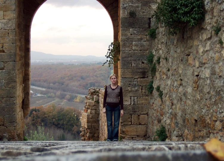 a woman is standing outside next to a window