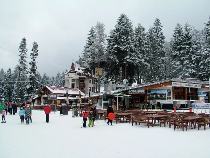 people walking in the snow near an outdoor food court