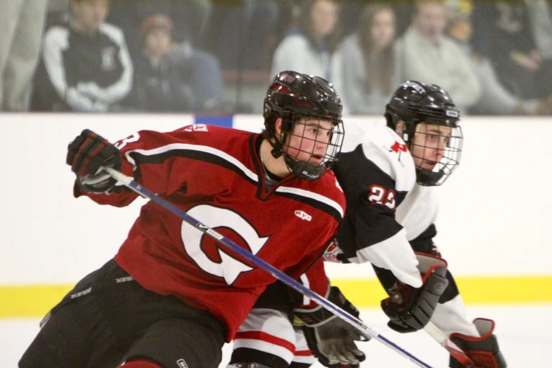 two men playing hockey during a game with other people