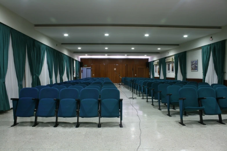 rows of blue chairs facing an empty meeting room