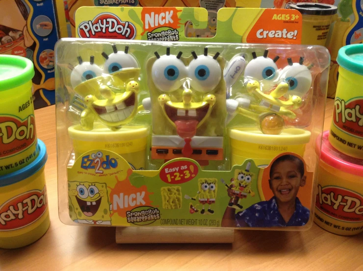 a yellow and green toy with many different faces
