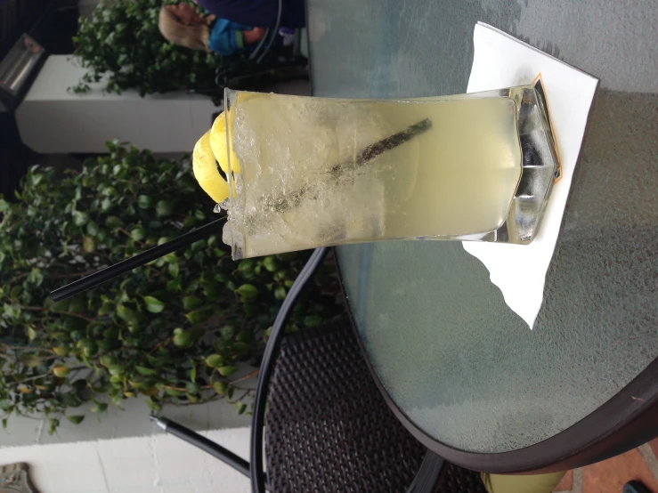 a drink on a table outside with water in it