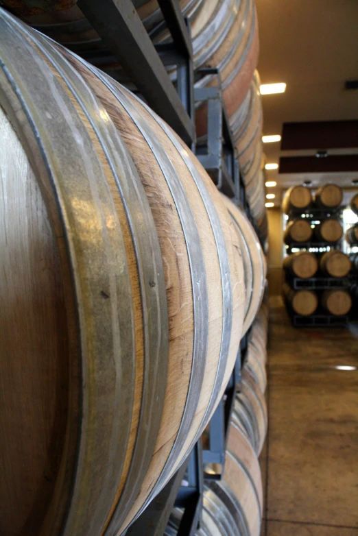 large wooden barrels stacked in a warehouse area