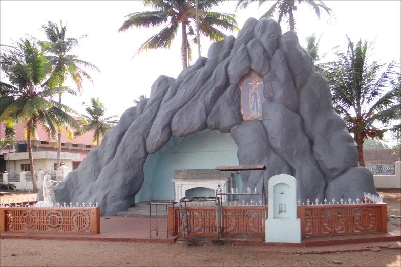 a large rock building with a gate around it