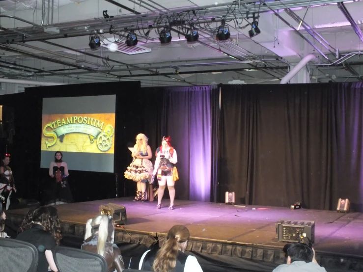 a group of people are sitting on stage while an instructor is speaking