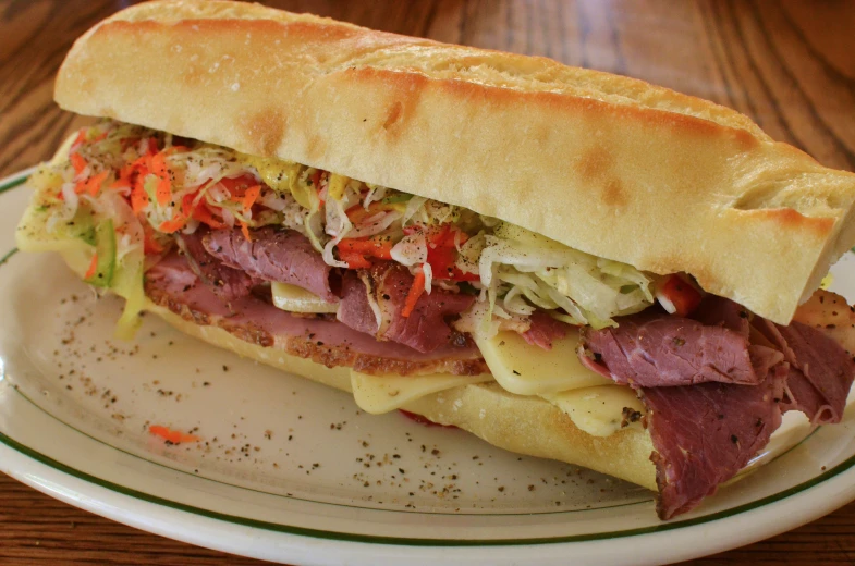 a sandwich with meat and various vegetables on a plate