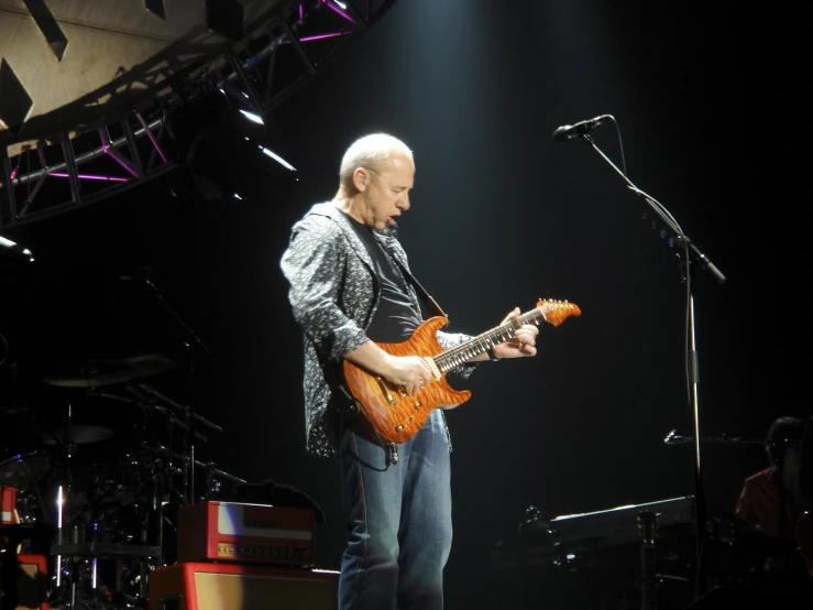 a man that is standing on a stage with an electric guitar
