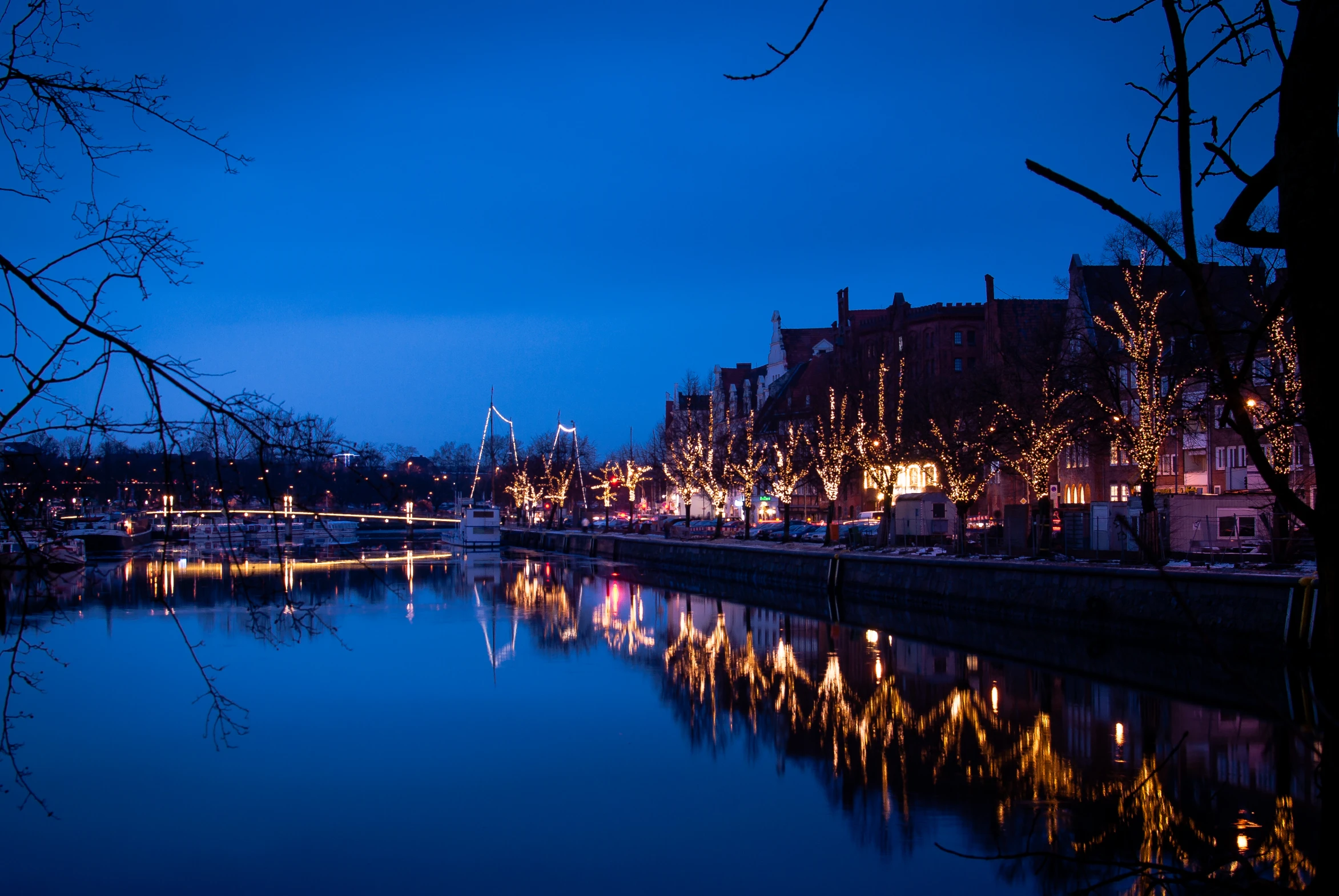 lights and decorations are around a waterway in front of a city