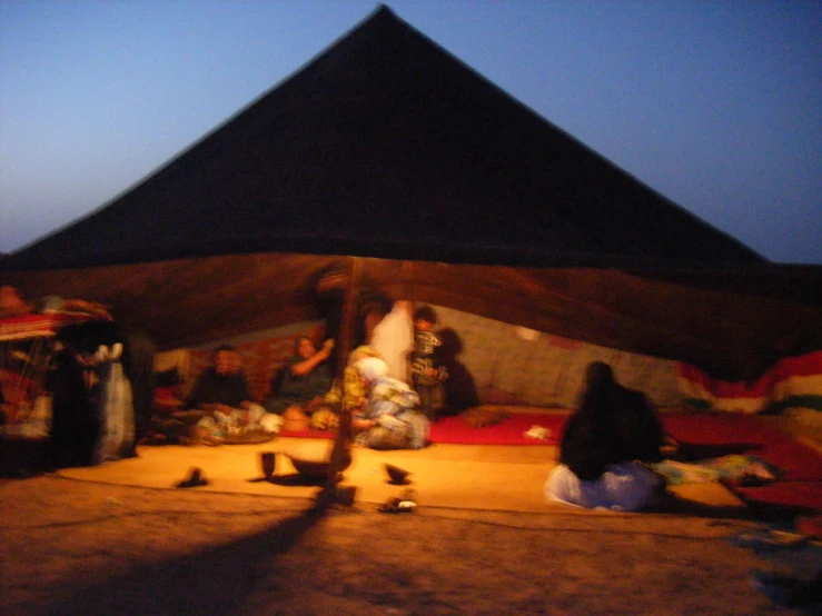 the view from inside a tent of several people sitting around