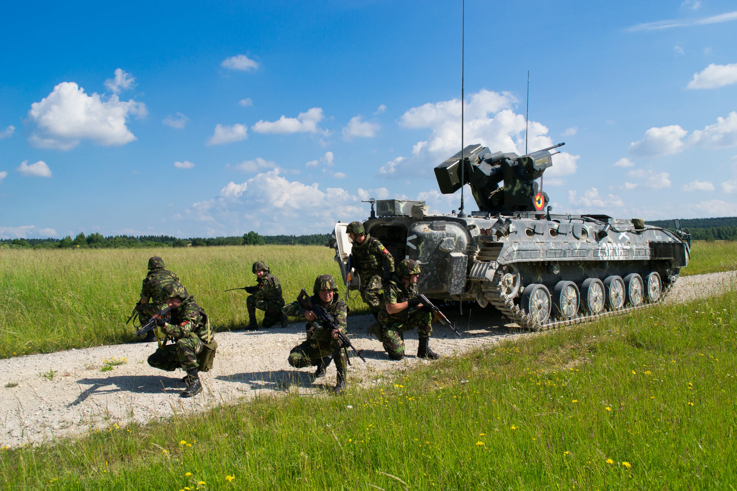 the soldiers are all running toward the armored vehicle