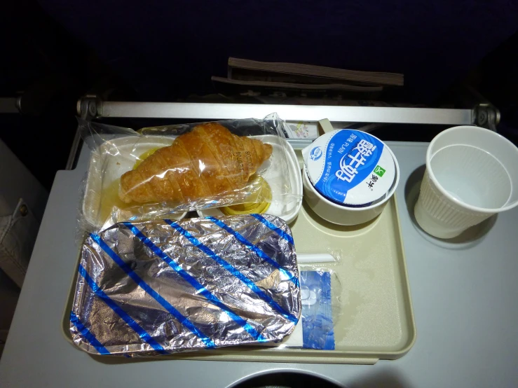 an airplane tray with food, drinks and snacks