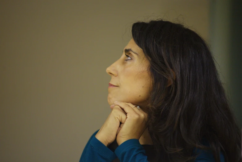 a woman is looking back with her hand on her face