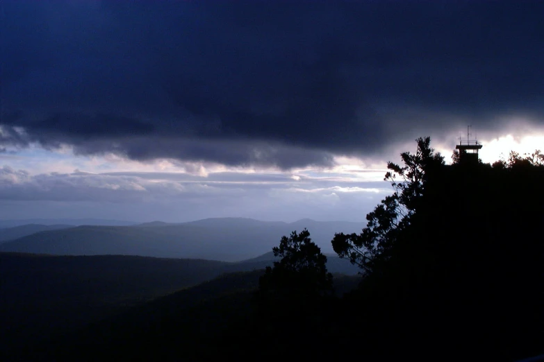 a dark scene with the sun in the clouds