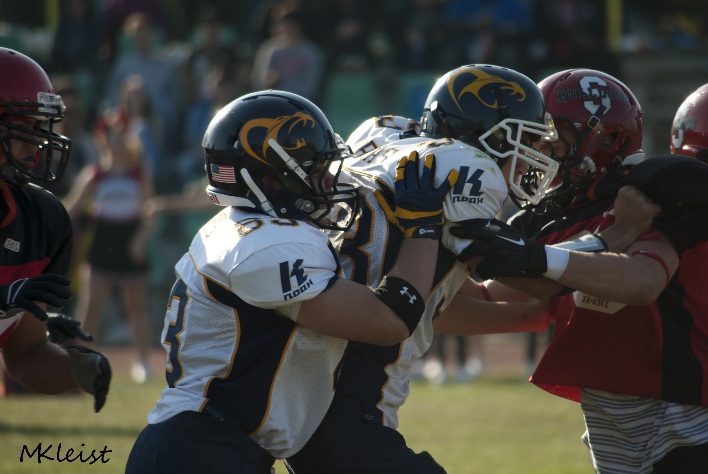 young men wearing helmets and football uniforms are playing a game