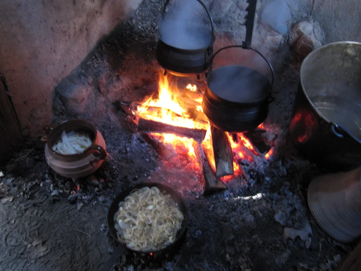 a fire in the fireplace with food cooking