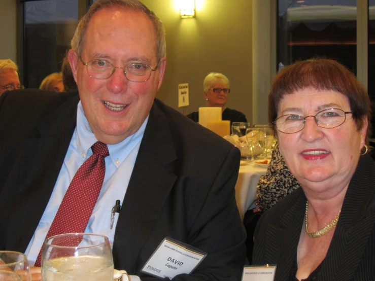 a couple in formal clothing sitting at a dinner table