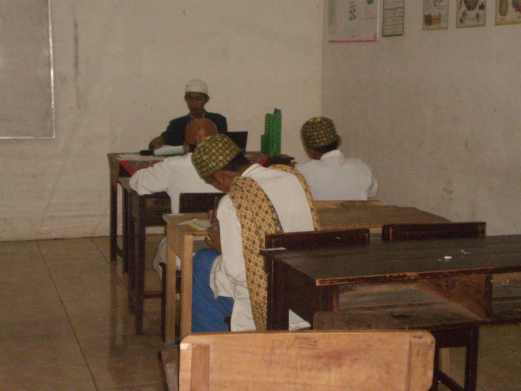 a group of people sitting at desks in a room