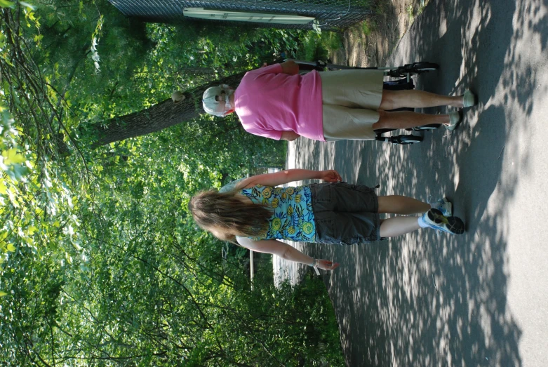 two women are walking up a hill near some trees