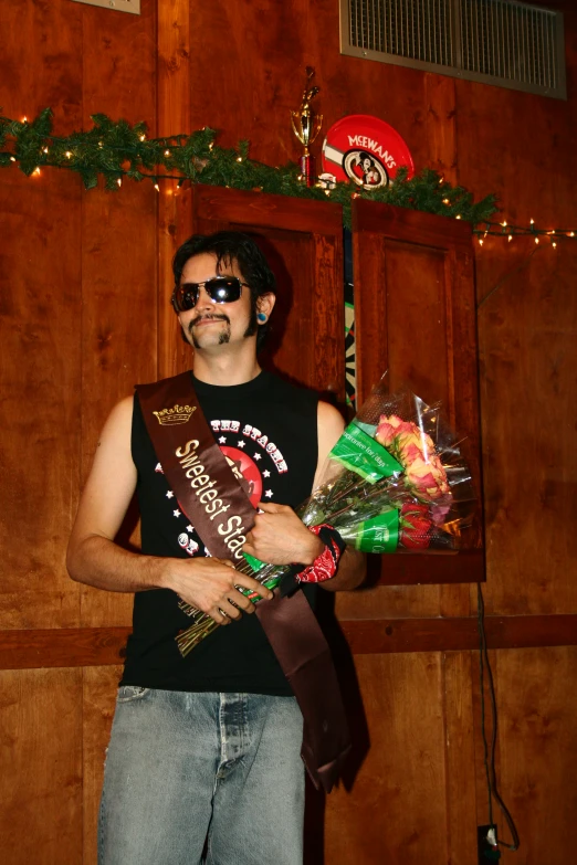 a man wearing glasses with christmas decorations holding a bouquet