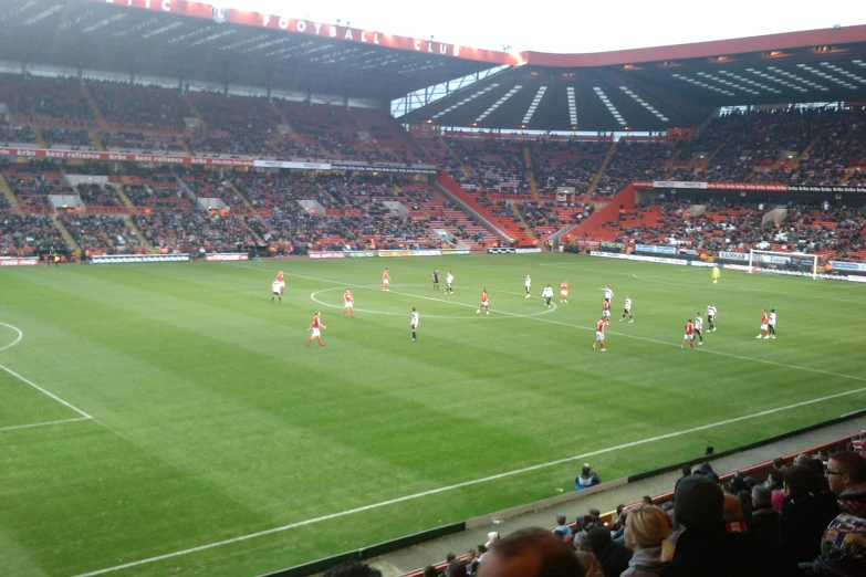 an empty soccer stadium filled with players on the field