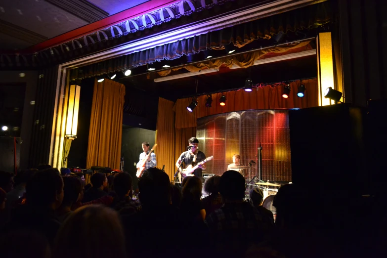 a band playing on a stage surrounded by people